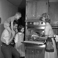 Majka pokazuje svježe pečenu piletinu za muž i djecu print