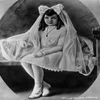 Claudette Colbert sjedi na krevetu, noseći bijelu haljinu s veo foto ispisom